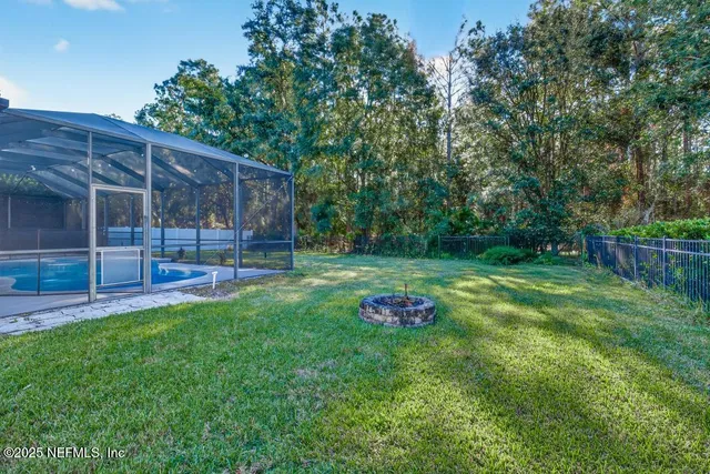 a view of a backyard with table and chairs and wooden fence