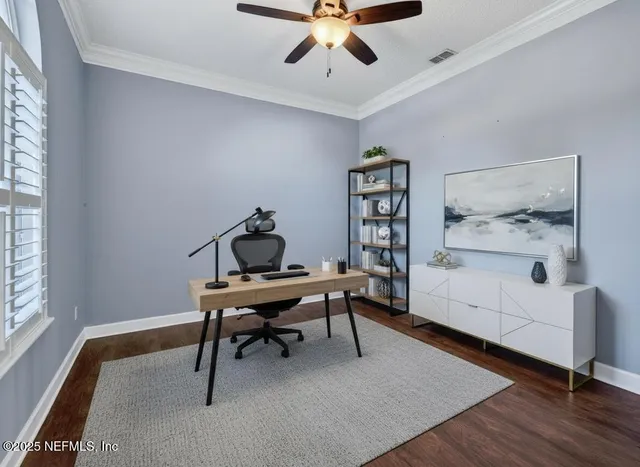 a view of a workspace with furniture and a window