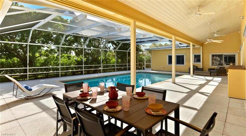 586 Yucca Road Naples, FL 34102 - Photo 22 of 26 View of pool with a lanai, a patio, a sunroom, and outdoor dining space
