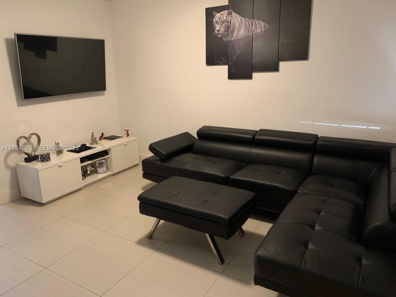 13215 Southwest 57th Terrace, Unit 206 Miami, FL 33183 - Photo 11 of 27 a living room with furniture and a flat screen tv