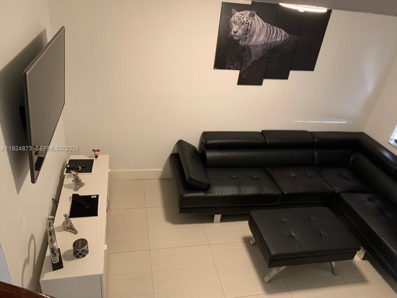 13215 Southwest 57th Terrace, Unit 206 Miami, FL 33183 - Photo 12 of 27 a living room with a couch and a flat screen tv