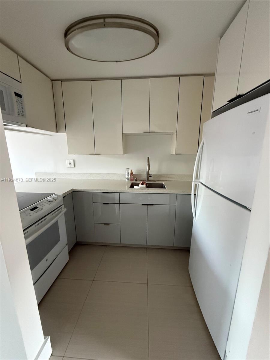 13215 Southwest 57th Terrace, Unit 206 Miami, FL 33183 - Photo 15 of 27 a kitchen with a sink a refrigerator and cabinets