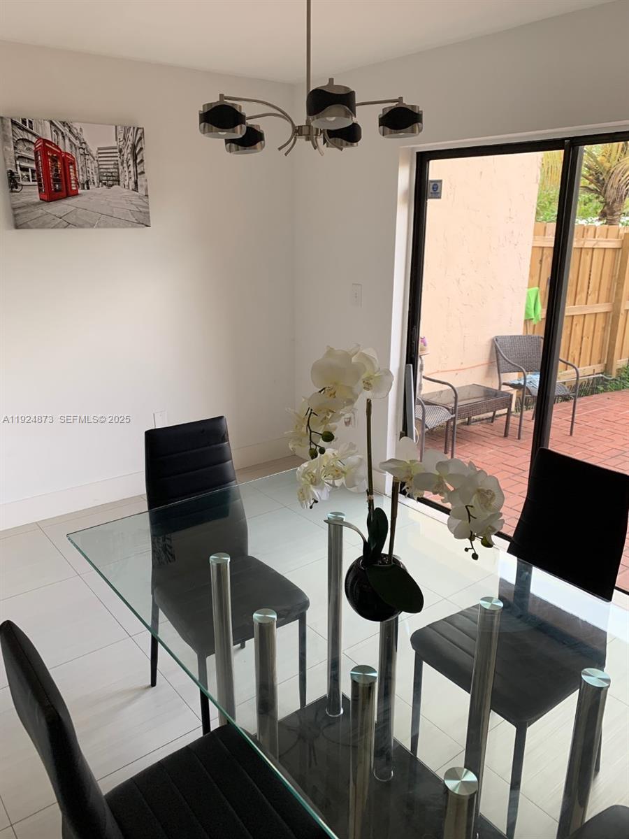 13215 Southwest 57th Terrace, Unit 206 Miami, FL 33183 - Photo 4 of 27 a table room with furniture and a floor to ceiling window