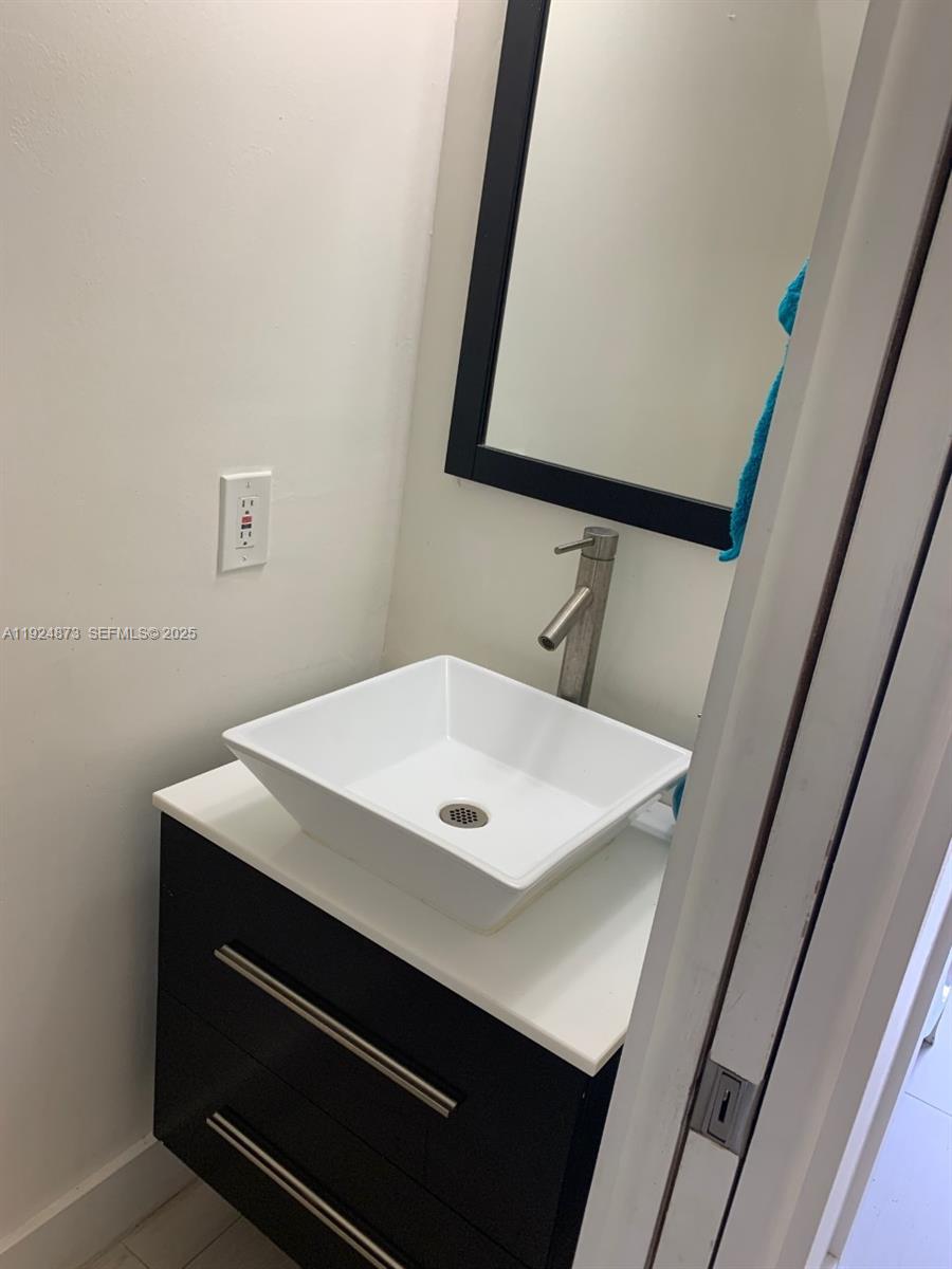 13215 Southwest 57th Terrace, Unit 206 Miami, FL 33183 - Photo 7 of 27 a bathroom with a sink and a mirror