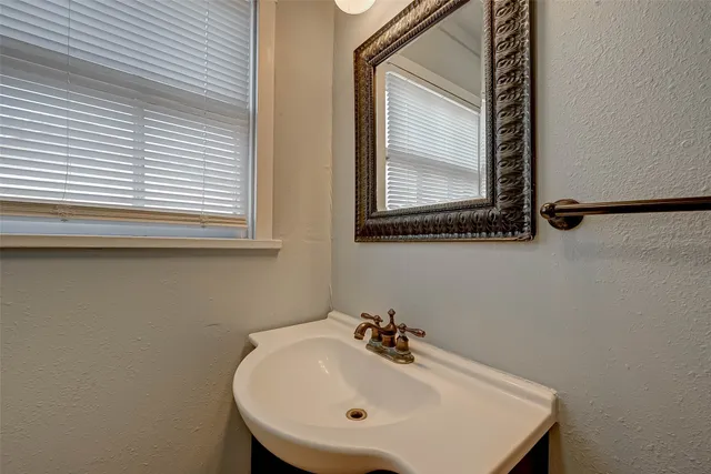 a bathroom with a sink a mirror and a window