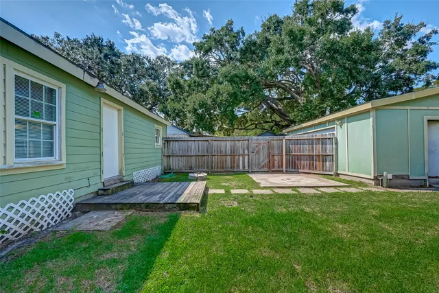 a view of a backyard with table and chairs and wooden fence