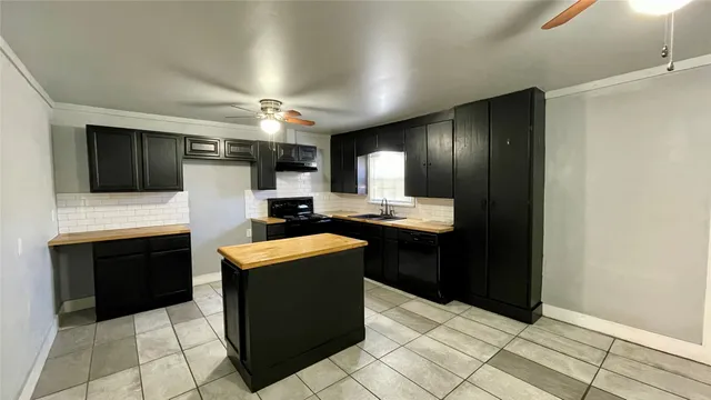 a kitchen with granite countertop a refrigerator and a stove top oven