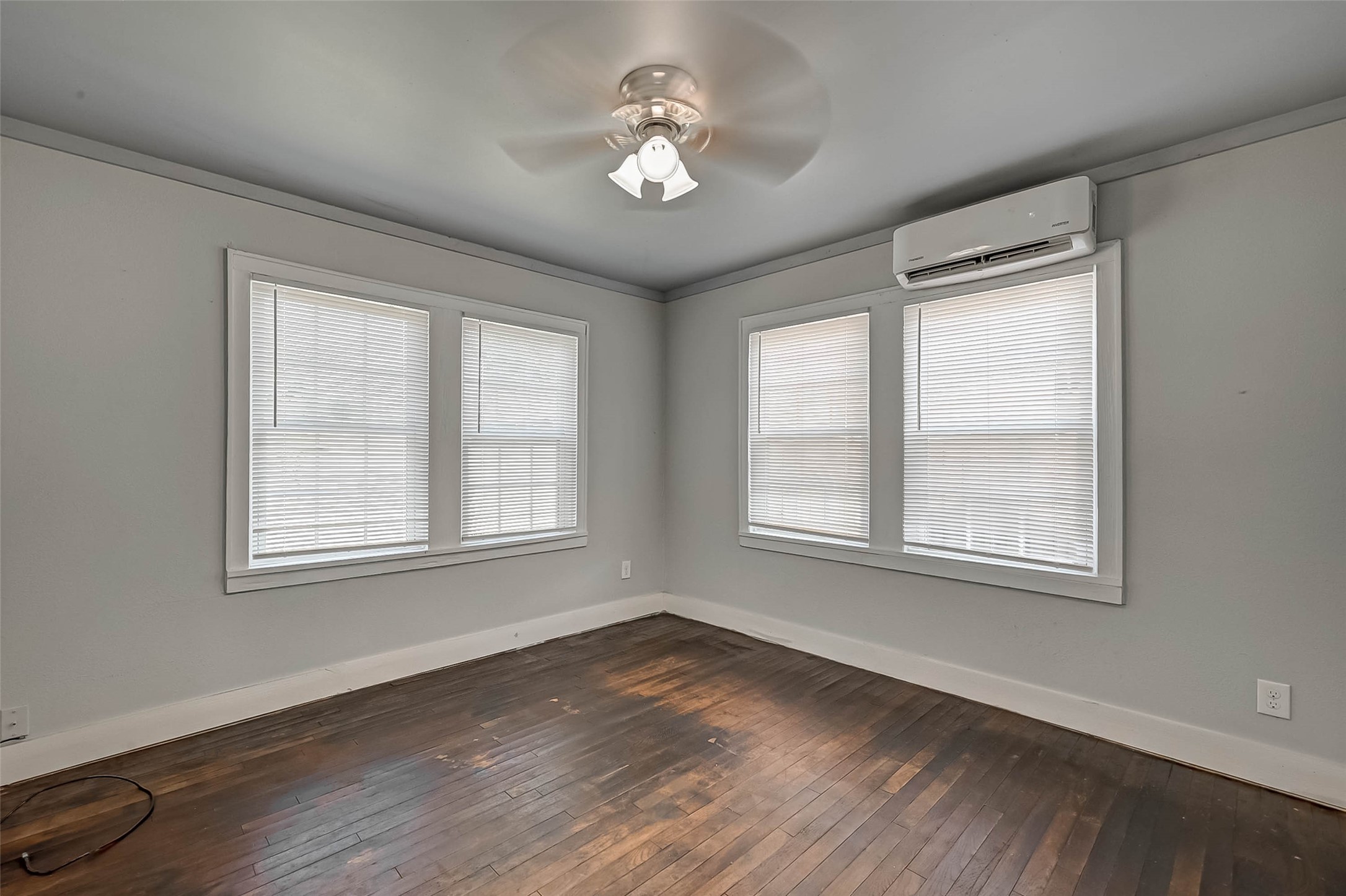 1018 West Sealy Street Alvin, TX 77511 - Photo 7 of 16 a view of an empty room with a window and wooden floor