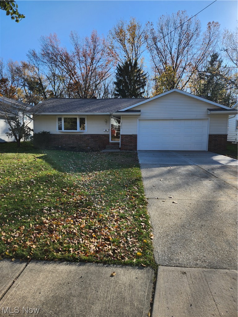 View of front of house with a garage and a front lawn
