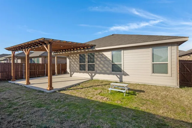 a view of a house with backyard and sitting area