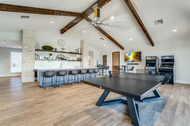a living room with stainless steel furniture kitchen view and a table