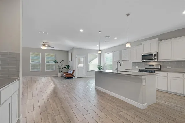a view of a kitchen with cabinets stainless steel appliances wooden floor and a counter top space