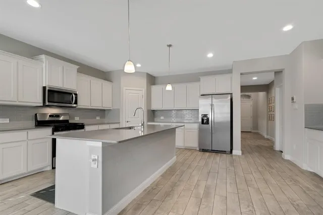 a kitchen with stainless steel appliances a refrigerator sink and microwave