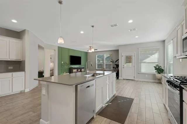 a large kitchen with kitchen island a sink and a stove top oven