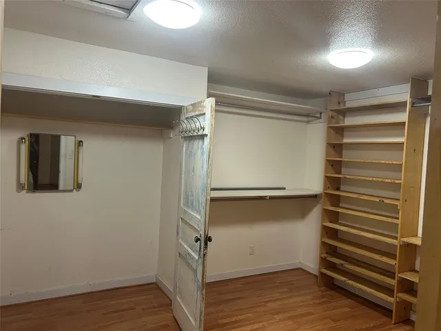 a view of walk in closet with empty racks