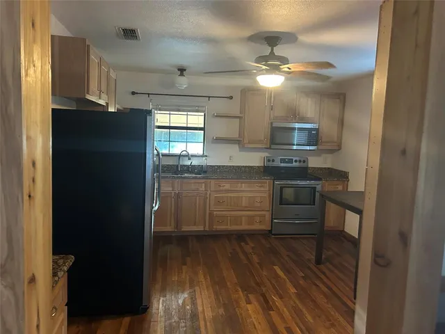 a kitchen with a refrigerator and a stove top oven