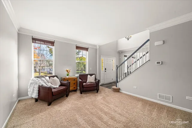 a living room with furniture stairs and a window