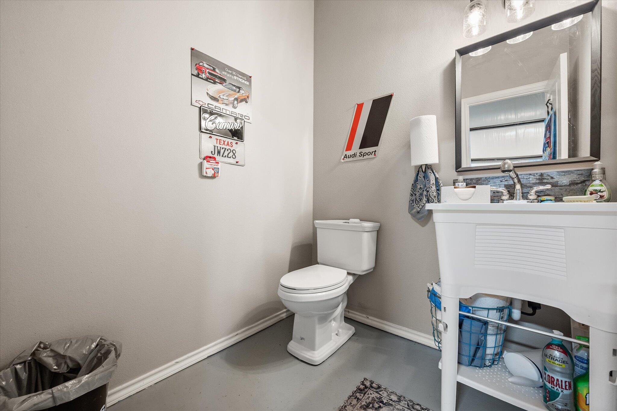 767 North Sandhill Road Tahoka, TX 79373 - Photo 9 of 27 a bathroom with a toilet a sink and a mirror