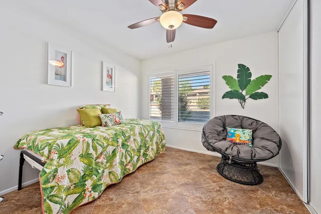 a bedroom with a bed potted plant on a dresser and a chandelier