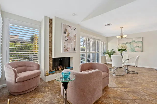 a living room with furniture fireplace and a large window