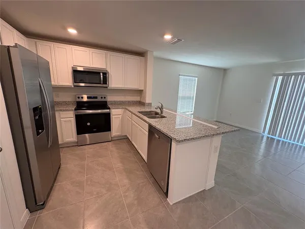 a kitchen with stainless steel appliances granite countertop a refrigerator stove and sink