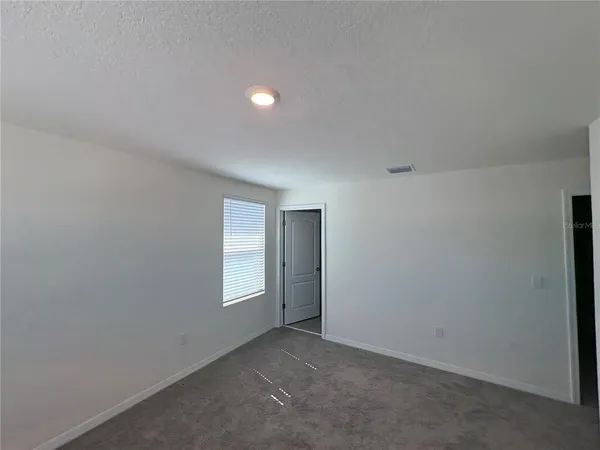 an empty room with windows and closet