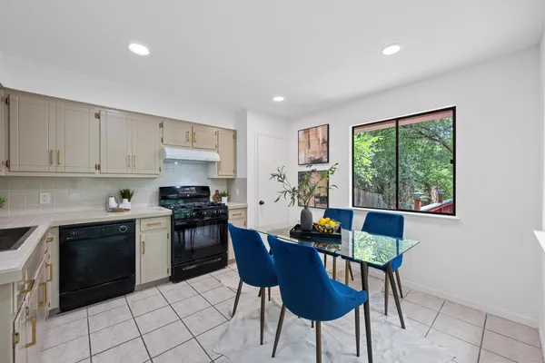 a kitchen with stainless steel appliances granite countertop a stove a sink a microwave a dining table and chairs