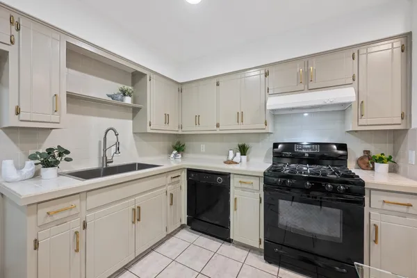 a kitchen with cabinets appliances a sink and a counter top