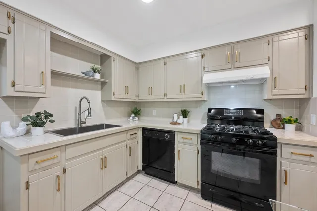 a kitchen with white cabinets and appliances