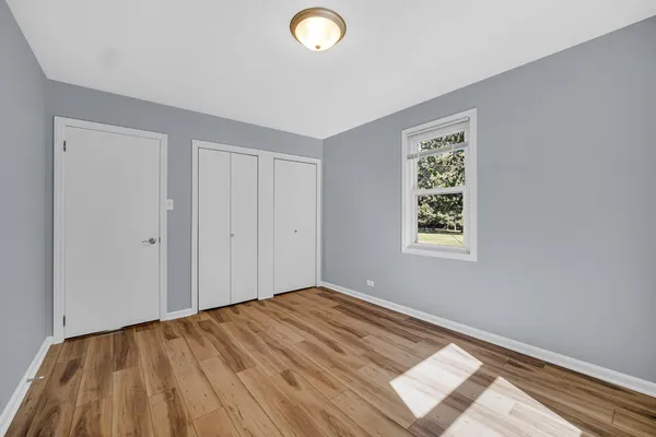 a view of a room with wooden floor and window