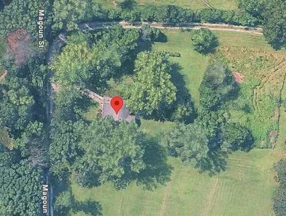 a view of a lake with a yard and large trees