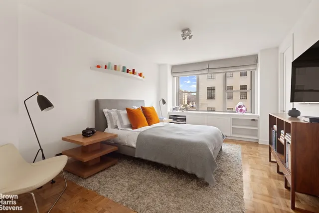 a bedroom with bed and a flat tv screen on dresser
