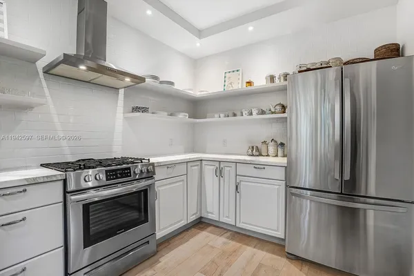a kitchen with cabinets stainless steel appliances and wooden floor