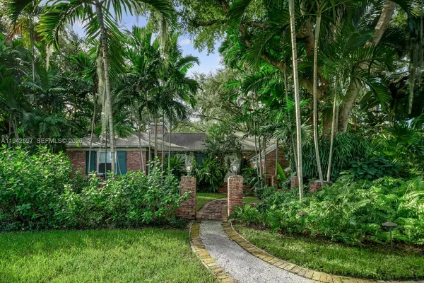 a front view of a house with a yard and trees