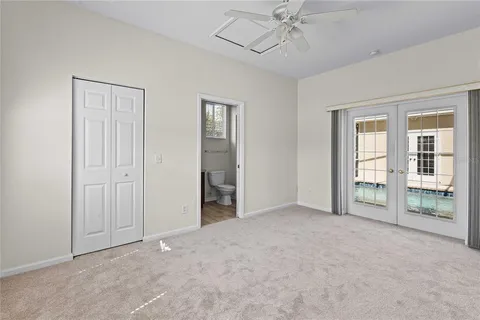 an empty room with chandelier fan and glass door