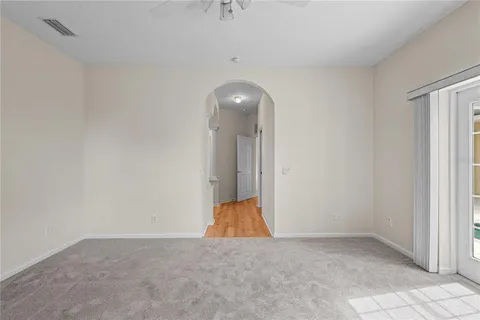 an empty room with wooden floor and natural light
