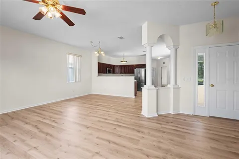 a view of a living room a hallway with wooden floor and staircase
