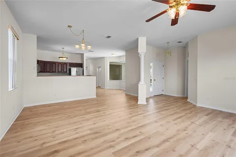 a view of a livingroom with a ceiling fan wooden floor and chandelier