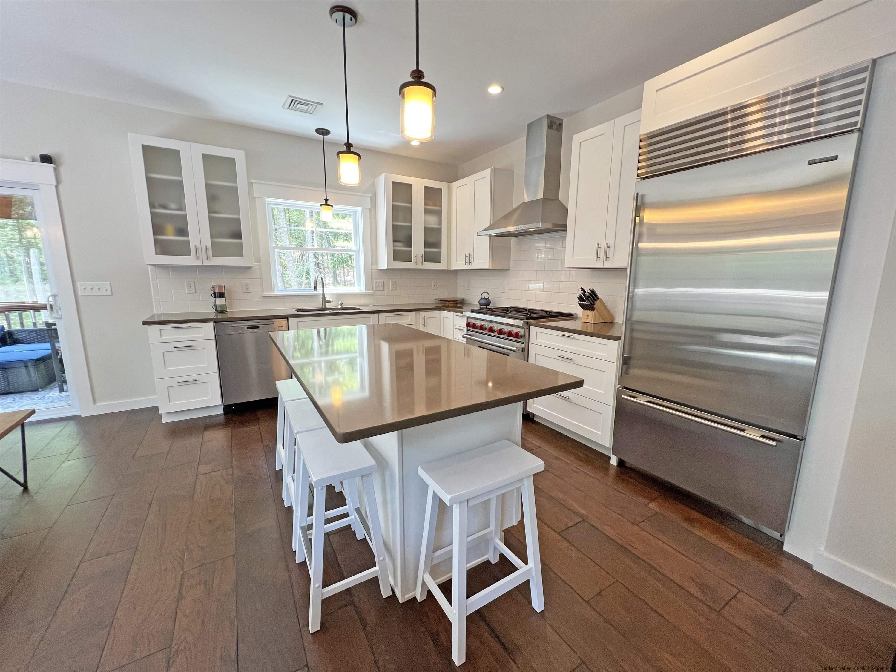 9 Magnolia Kingston, NY 12401 - Photo 11 of 33 a kitchen with stainless steel appliances granite countertop a stove top oven a sink dishwasher and a refrigerator with wooden floor
