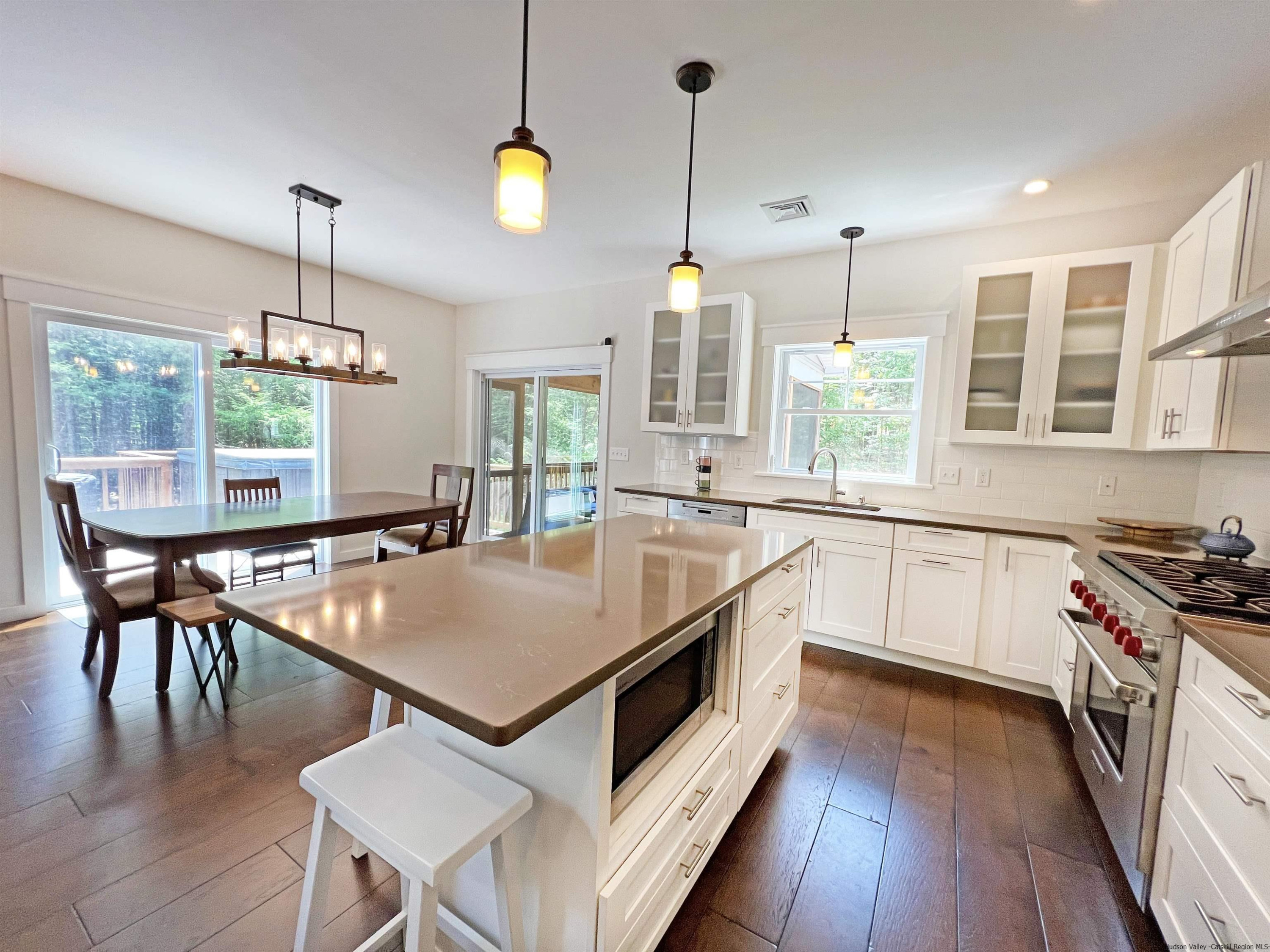 9 Magnolia Kingston, NY 12401 - Photo 10 of 33 a kitchen with stainless steel appliances granite countertop a stove a sink a kitchen island a stove a dining table chairs and white cabinets