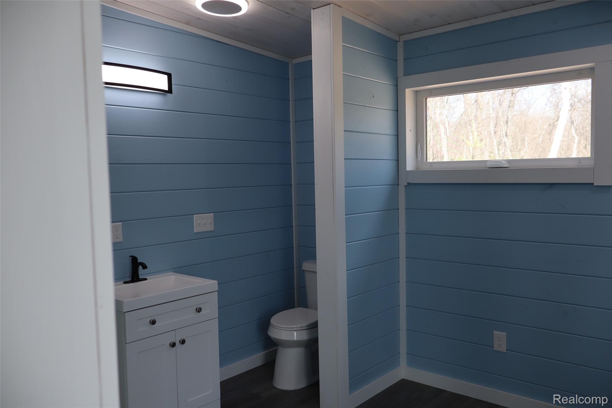 1545 South La Chance Road Lake City, MI 49651 - Photo 27 of 51 Half bath with vanity and wooden walls