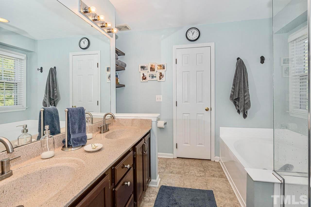 8824 Whitby Court Raleigh, NC 27615 - Photo 13 of 25 a bathroom with a granite countertop sink and a mirror
