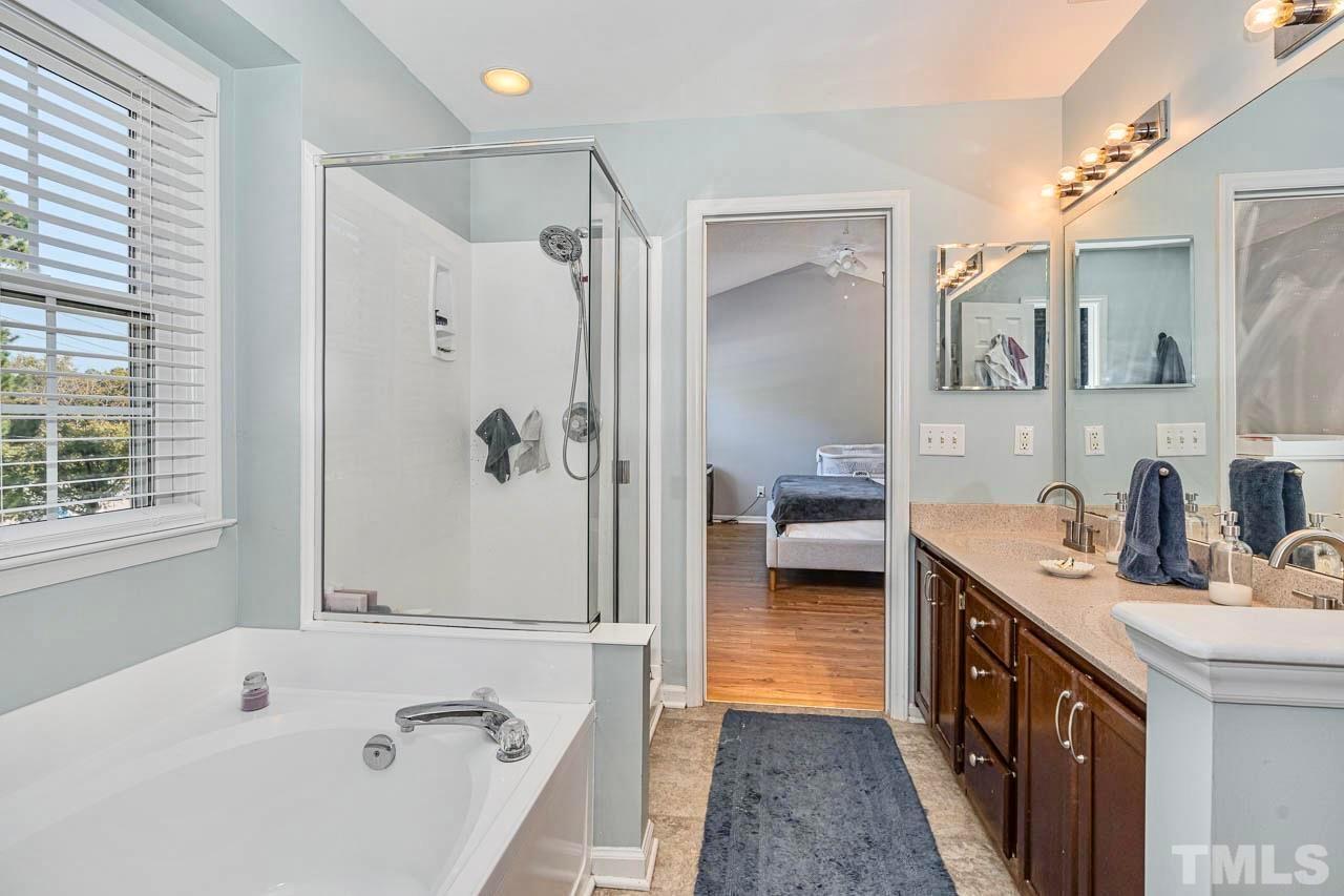 8824 Whitby Court Raleigh, NC 27615 - Photo 14 of 25 a en suite spacious bathroom with a tub sink double vanity and mirror