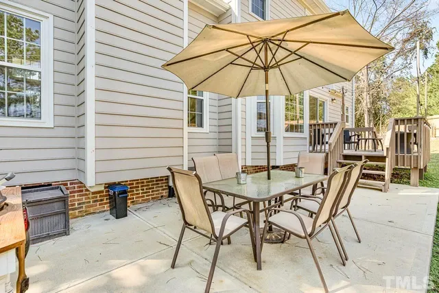 a patio with a table and chairs under an umbrella