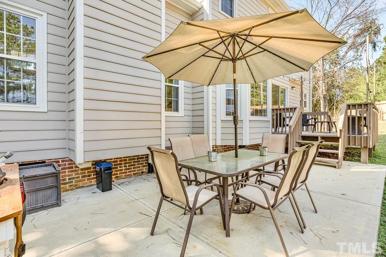 8824 Whitby Court Raleigh, NC 27615 - Photo 21 of 25 a patio with a table and chairs under an umbrella