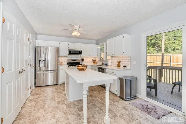 a kitchen with refrigerator cabinets and wooden floor