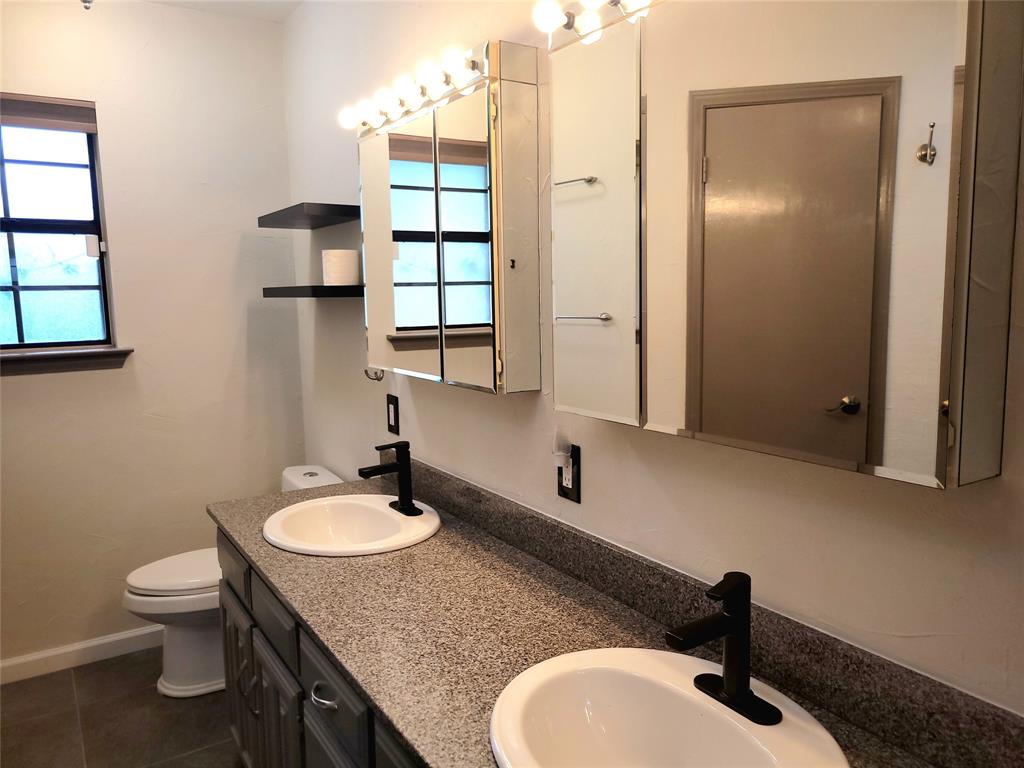 912 North Dove Road Grapevine, TX 76051 - Photo 21 of 36 a bathroom with a granite countertop sink toilet and shower