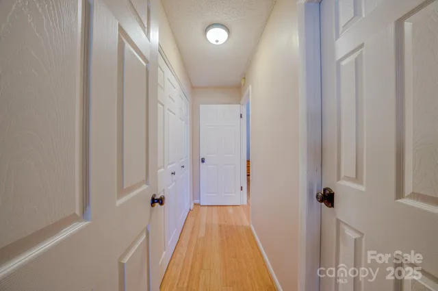 a view of a hallway with wooden floor and staircase
