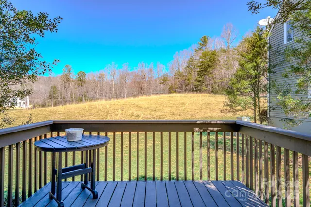 a view of a roof deck with wooden floor and fence and a yard