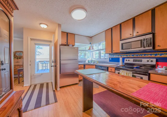 a kitchen that has a lot of cabinets a sink and appliances in it